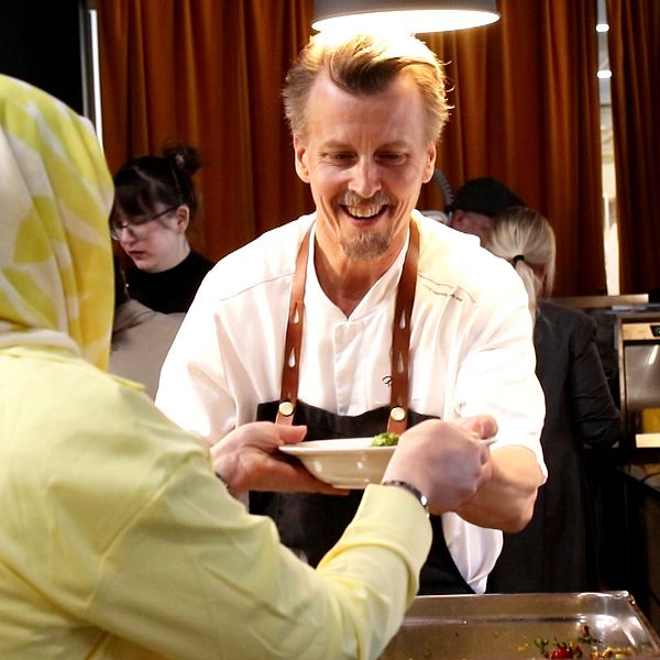 Kocken Paul Svensson serverar en kvinna soppa.