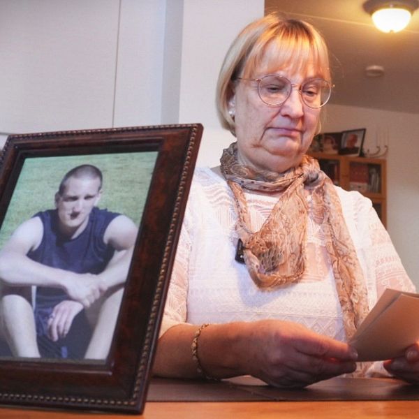 En mamma tittar på foton på sin försvunna son.