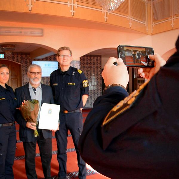 Polisen tar en bild tillsammans med Fittja Moskéns ordförande Ismail Okur. I handen har han diplomet som tack för samarbetet den 15 september 2023.