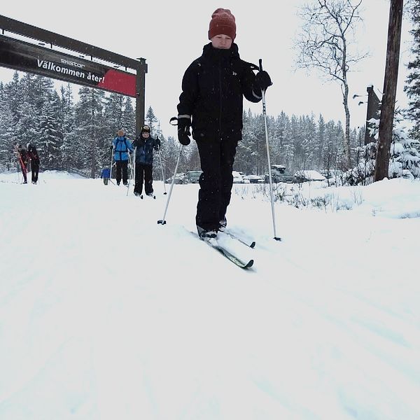 Ett barn åker ned för en skidbacke i Sälen, bakom kommer fler skidåkare.