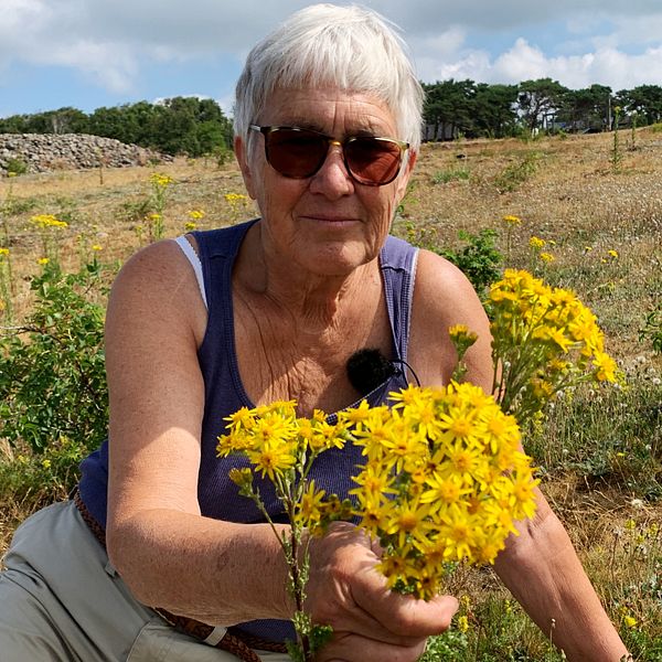 Margareta Lindgren från Hallands botaniska förening håller i en bukett med stånds.