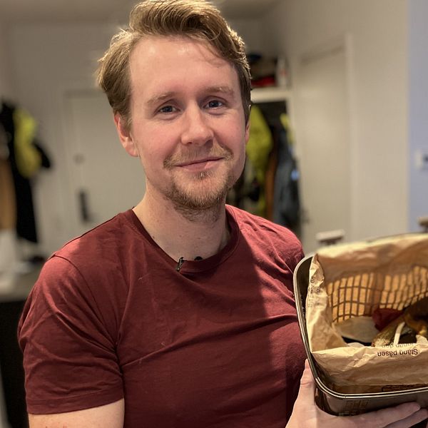 Man med matavfallspåse i handen.