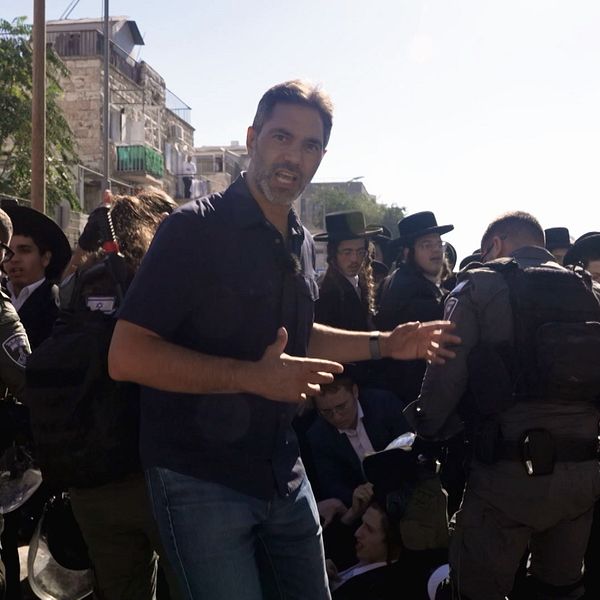 Samir Abu Eid davanti a una folla che affronta la polizia in una strada a Gerusalemme.