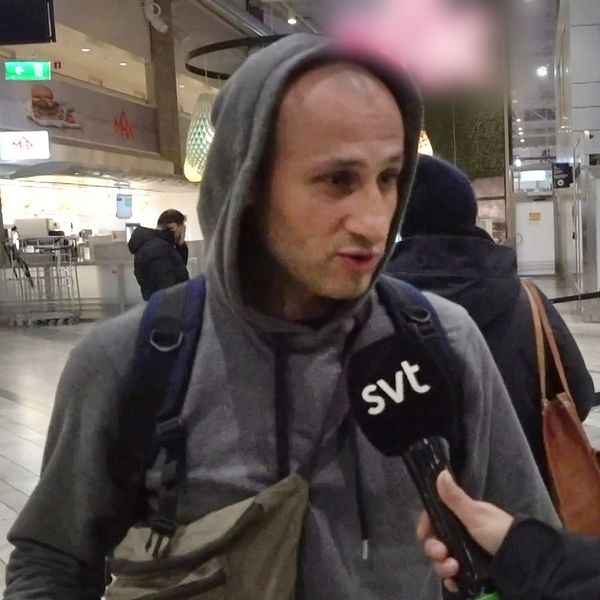 En man med luvtröja och väskor i ankomsthallen på Landvetter flygplats utanför Göteborg, har just anlänt i Sverige från Gaza