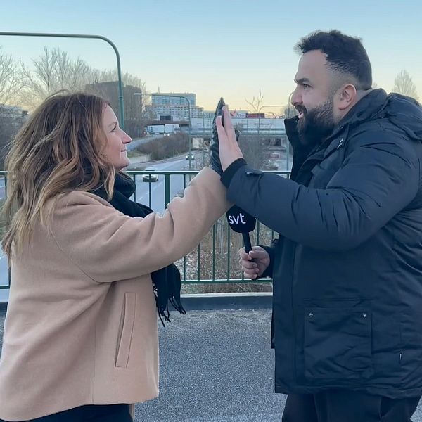 Fanny Berg och Hamza Ftouni gör high five på en bro över trafikerad gata.