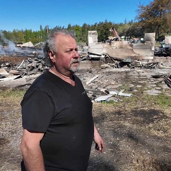 Mats Solönhaf framför nedbrunnen ladugård efter branden