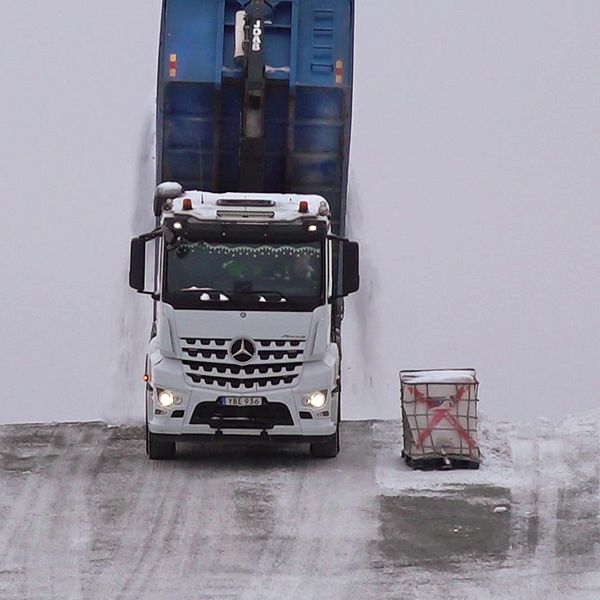 lastbil tömmer flaket på snö på Östersunds snötipp