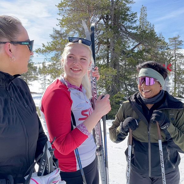 Tre unga kvinnor står med längdskidor vid Gruvens fäbod i Sälen