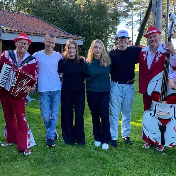 Bandet Larz-Kristers står uppställda i Orrskogens Folkpark tillsammans med fyra ungdomar som besöker dansbandsveckan i Malung.
