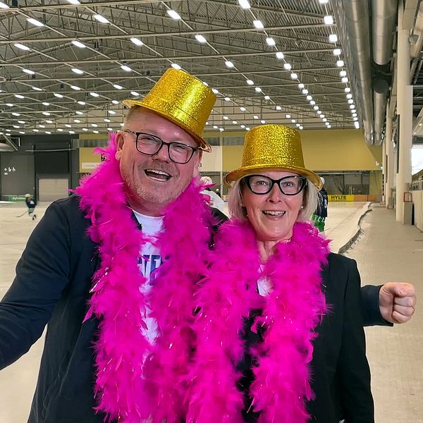 Man och kvinna i glitterhatt och boa runt halsen.