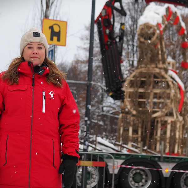 Kvinna står framför julbocken i Gävle.