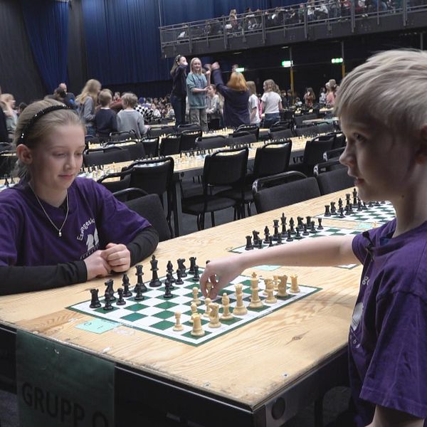 Två fjärdeklassare sitter mittemot varandra med ett schackbräde mellan dem.