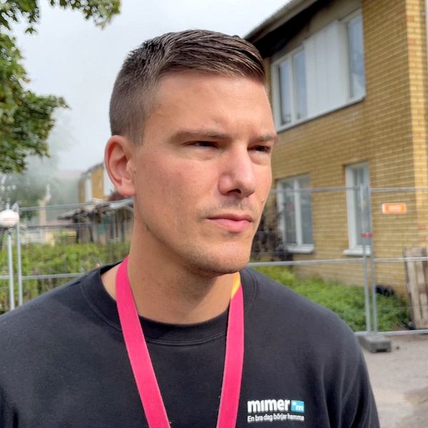 Martin Björnberg, distrikstchef hos kommunala bostadsbolaget Mimers i Västerås framför en brandhärjad byggnad.