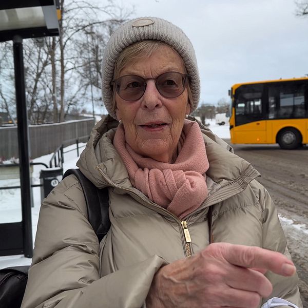 en kvinna framför en busshållsplats