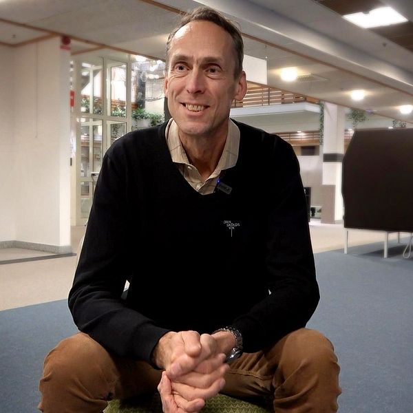 en man i tröja och skjorta, leende, sitter på huk, håller ihop sina händer, han heter Fredrik Holmgren, näringslivschef i Örnsköldsvik