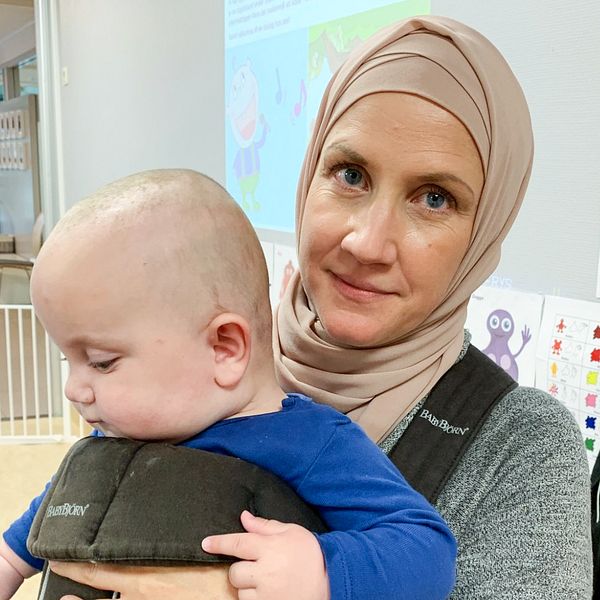 Porträttbild på mamman Carolina Nyrén som håller i sin bebis.