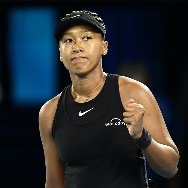 Tennis spelaren firar efter att ha vunnit en poäng i en match, klädd i en svart sportoutfit med en Nike-logotyp.