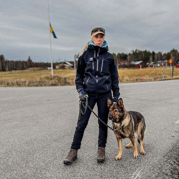kvinna med hund som står i vägkorsning