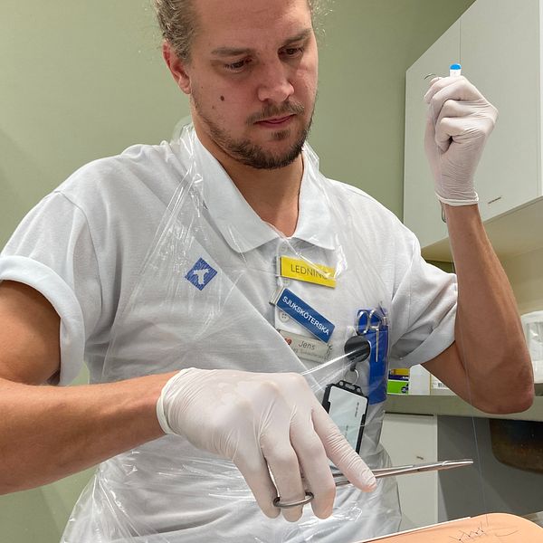 Sjuksköterska som tränar på att sy sår på en övningsmodell.