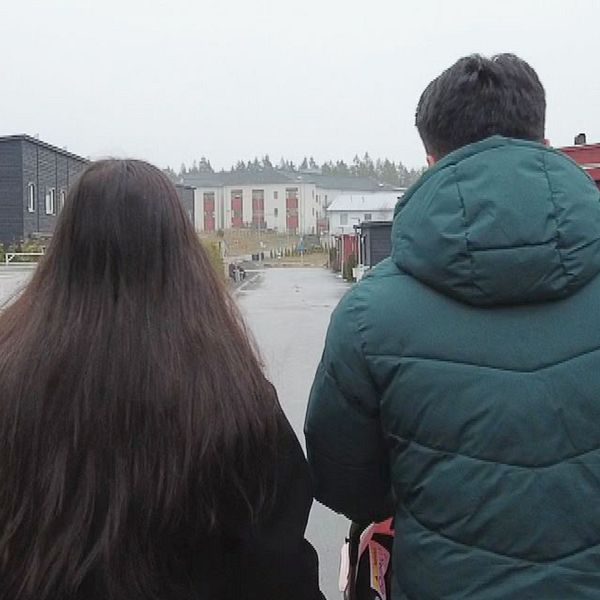 En familj promenerar i ett bostadsområde.