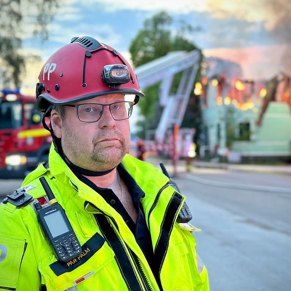 Räddningsledare Pär Palm framför brinnande hus i Bergsjö.