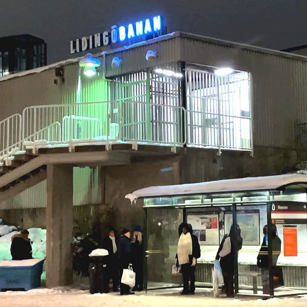 Resenärer i ett vinterkallt Ropsten väntar på bussen som ersätter Lidingöbanan