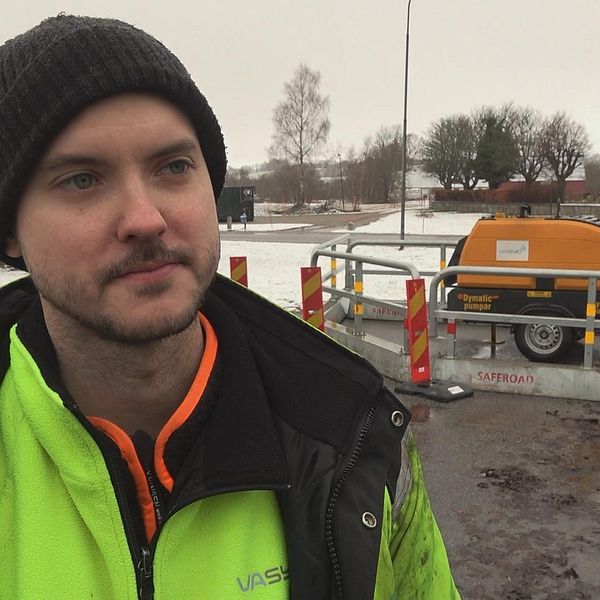 Andreas Löfgren, driftstekniker VA Syd, framför en vattenpump som hjälper till mot översvämningarna i Revingeby.