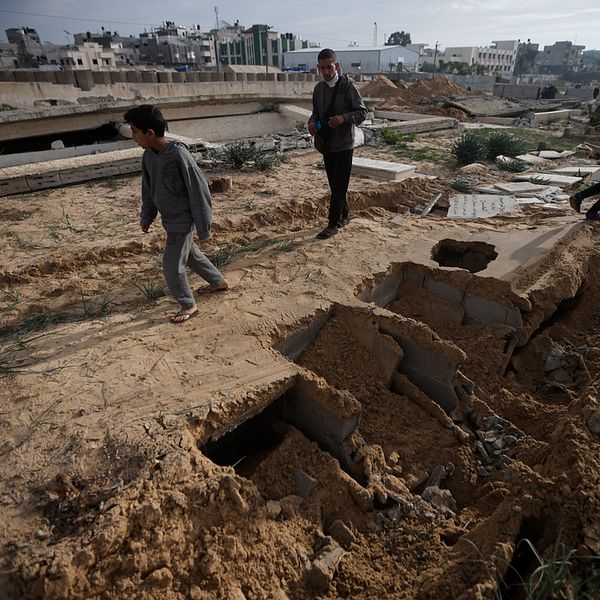 Palestinier i staden Khan Yunis undersöker skadorna på en gravplats efter att