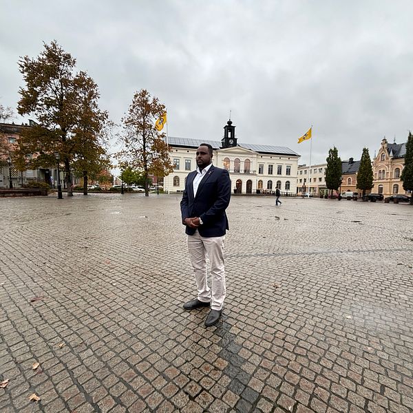 Hanad Ali står på ett torg framför rådhuset i Köping.