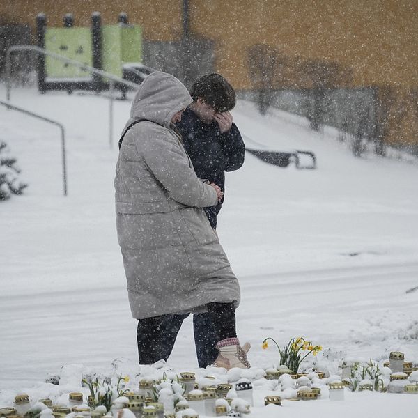 Två personer lägger ner ljuslyktor