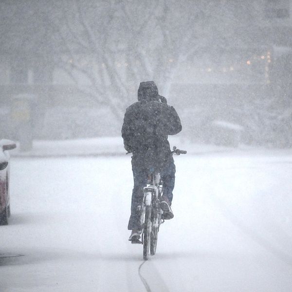 En cyklist som cyklar i snöoväder.