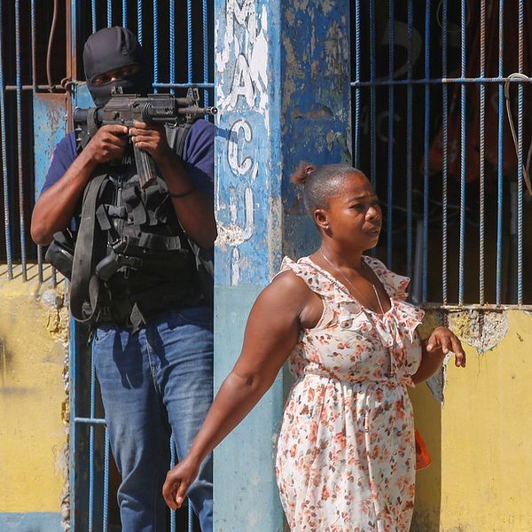 Kvinna i Haiti passerar en militärpolis utstationerad i huvudstaden Port-au-Prince.