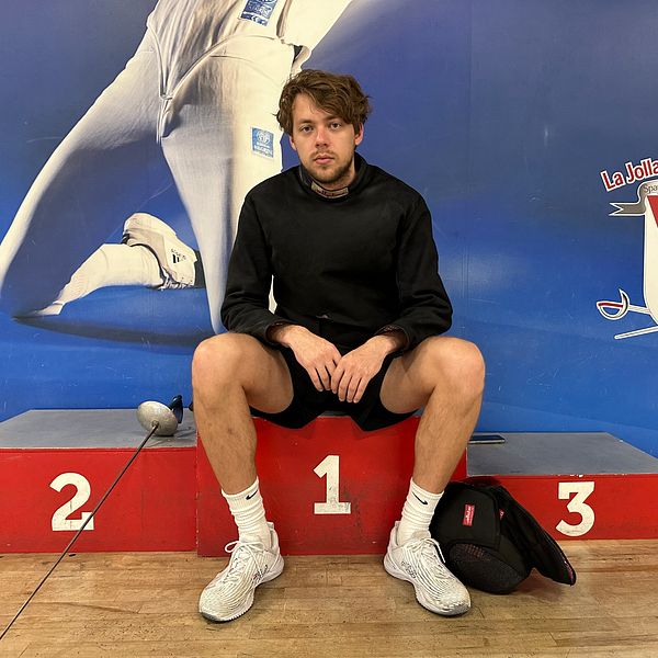 Fäktaren Konstantin Lokhanov, från Ryssland men som nu bor i USA, sittandes på en prispall i en fäkntingssal.