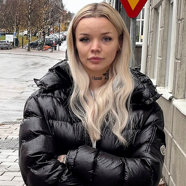 Tilde Rutström står utomhus i svart jacka med armarna i kors framför en husfasad.