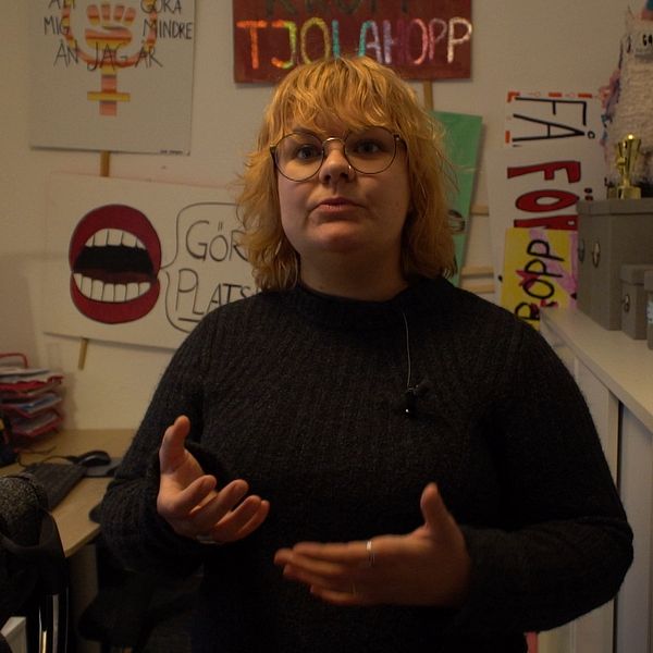 Kvinna framför plakat på kontor