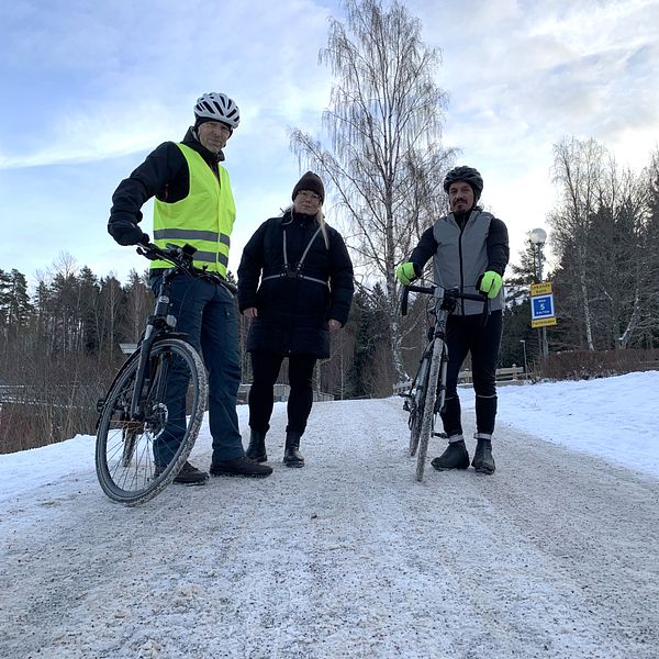 Cyklister står på en snöig väg.