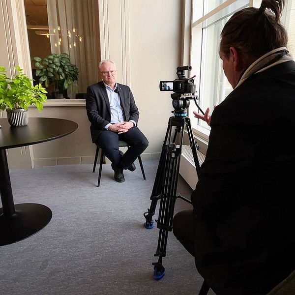 Glenn Nordlund sitter på en stol framför en kamera vid en intervju.