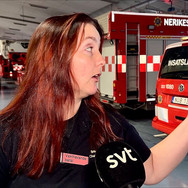 vakthavande befäl står i brandkårens vagnhall och blir intervjuad