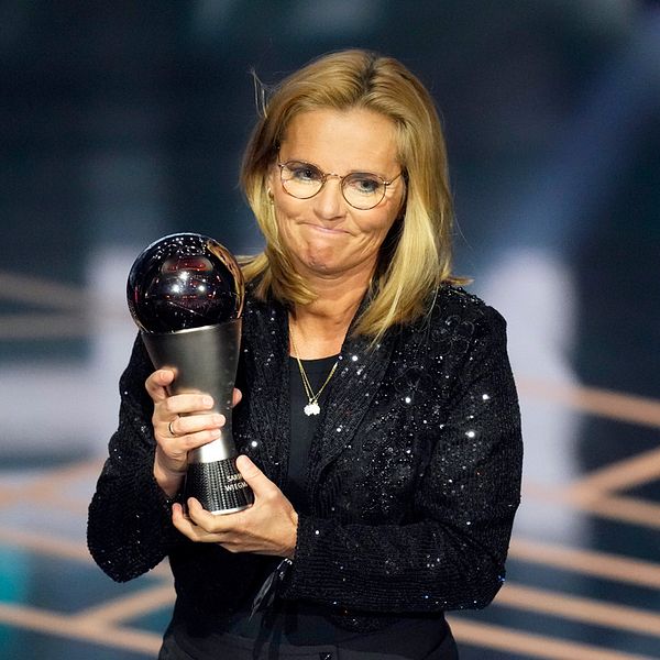 Englands förbundskapten Sarina Wiegman, klädd i svart glittrig kavaj, håller i priset hon vann på Fifa-galan The best på måndagskvällen.