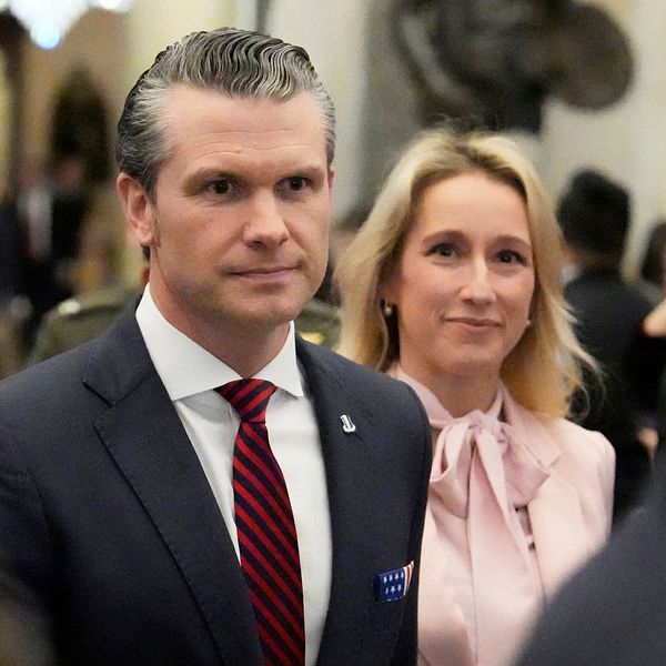 Välklädda personer minglar i en stor konferenshall.