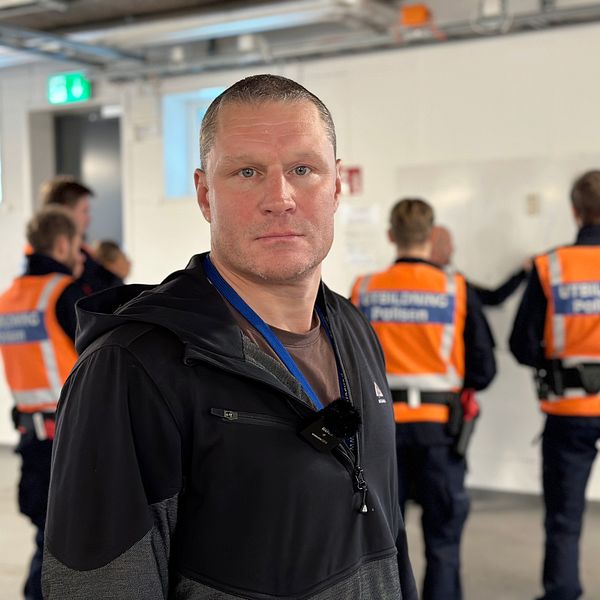 Porträtt på studierektor Pontus Bergh på polisutbildningen i Umeå. Polisstuderande i förgrunden.