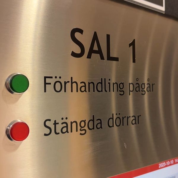 Skylt utanför rättssal 1 med texten ”Förhandling pågår” och ”Stängda dörrar”.