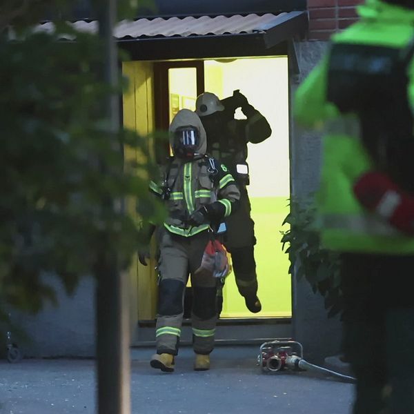 Rökdykare från räddningstjänsten lämnar bostadshus i Sollentuna efter detonation.