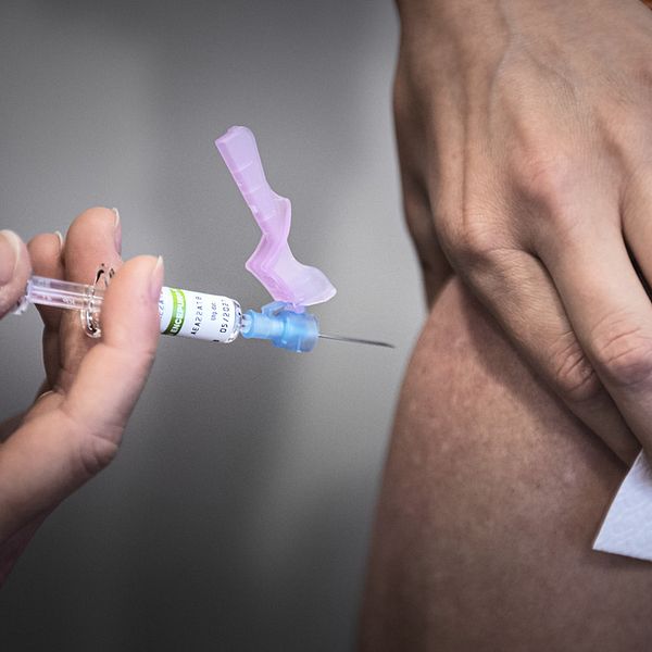En spruta TBE-vaccin förs mot en arm