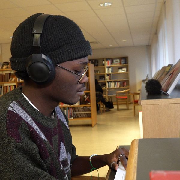 En student sitter och pluggar i biblioteket i Eskilstuna.