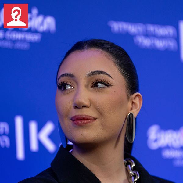 Person på presskonferens med Eurovision Song Contest-logga i bakgrunden.