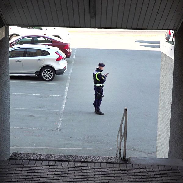Vaktmästare i uniform står på en parkeringsplats i Biskopsgården efter att ett dubbelmord inträffat i stadsdelen på Hisingen i Göteborg