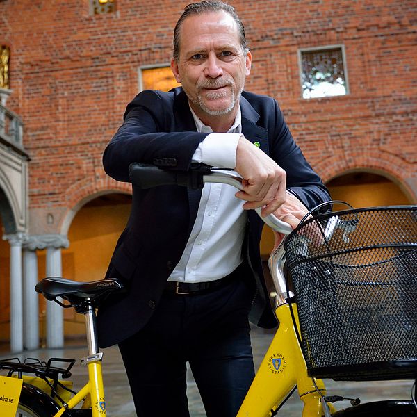 Daniel Helldén står vid cykel i Stockholms stadshus