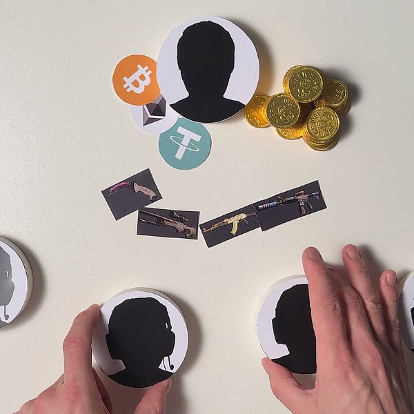 Ett bord med anonyma ansikten, leksakspengar, kryptosymboler på.