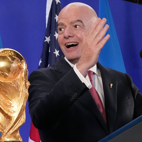 Gianni Infantino talar bredvid VM-pokalen vid ett podium